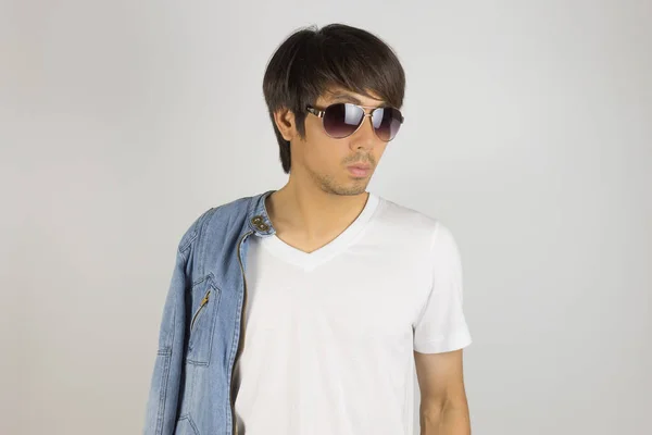 Joven asiático hombre en pantalones vaqueros o chaqueta de mezclilla usar gafas de sol y Sho — Foto de Stock