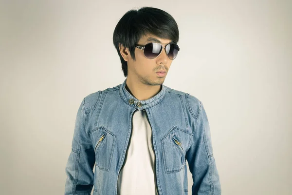 Молодой азиат в джинсах или джинсовой куртке носит солнцезащитные очки в винте — стоковое фото