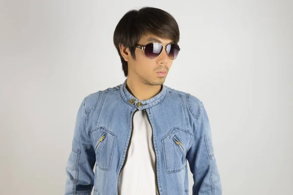 Молодой азиат в джинсах или джинсовой куртке носит солнцезащитные очки — стоковое фото