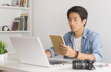 Asyalı Fotoğrafçı veya Freelancer Not Defterindeki Çalışma Zamanlamasını Denetliyor
