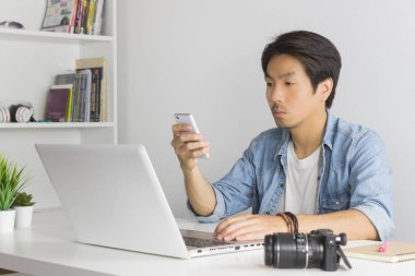 Asyalı Fotoğrafçı veya Freelancer, İçişleri Bakanlığı 'nda Smartphone ve Laptop ile Müşteriye Mesaj Gönder