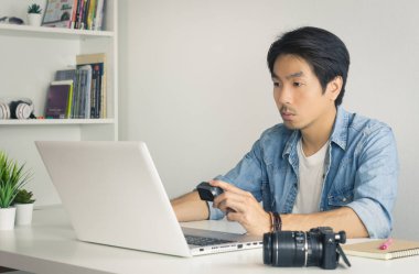 Asyalı Fotoğrafçı ya da Freelancer Dosya Aksiyon Kamerasında Bilgisayarla Eski Ton Ofisinde Kontrol Ediyor