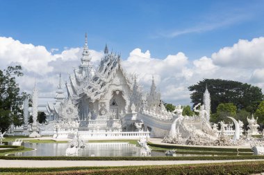 Chiangrai, Tayland - 7 Haziran 2020: Rong Khun Tapınağı veya Wat Rong Khun Mavi Gökyüzü Arkaplanı üzerinde Doğal Işık ile Yan Görünüm. Tayland 'daki Chiangrai Beyaz Tapınağı cazibesi