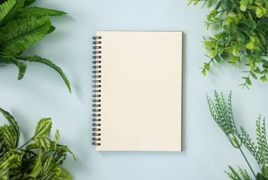 Mavi Pastel Minimalist Arkaplan Köşesinde Spiral Not Defteri ya da Sınırsız Tip ve Ofis Bitkileri