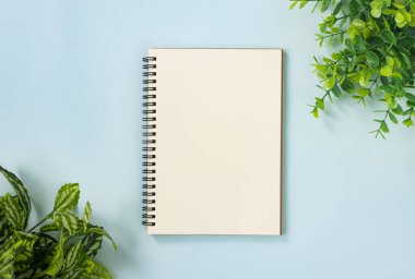 Spiral Not Defteri veya Satırsız Tip ve Ofis Bitkileri Üst Sağ Köşede ve Alt Sol Köşede Mavi Pastel Minimalist Arkaplanda