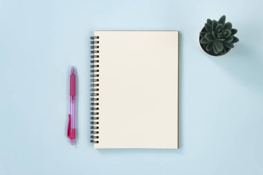 Mavi Pastel Minimalist Arkaplan Üzerine Çizgisiz Tip, Kalem ve Ofis Bitkisi ile Spiral Not Defteri
