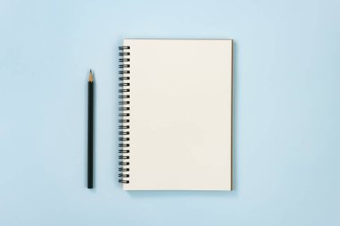 Mavi Pastel Minimalist Arkaplan Üzerine Çizgisiz Tip ve Kalem ile Spiral Not Defteri