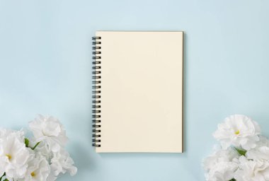 Mavi Pastel Minimalist Arkaplan 'da Çizgisiz Tip ve Beyaz Çiçeklerle Spiral Not Defteri