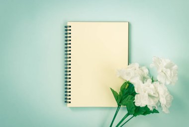 Spiral Not Defteri veya Çizgisiz Tür ve Beyaz Çiçekler Altında Mavi Pastel Minimalist Arkaplanda Klasik Ton