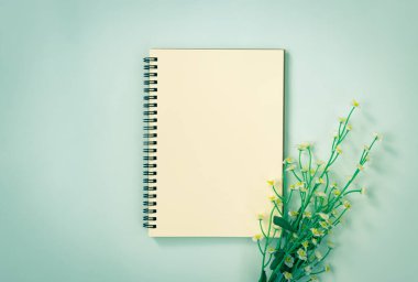Spiral Not Defteri ya da Çizgisiz Tür ve Beyaz Papatya Çiçekleri Altında Mavi Pastel Minimalist Arkaplanda Klasik Ton