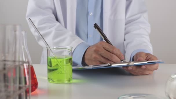 Young Scientist Man Lab Coat Writing Experimentele Resultaten Check Green — Stockvideo