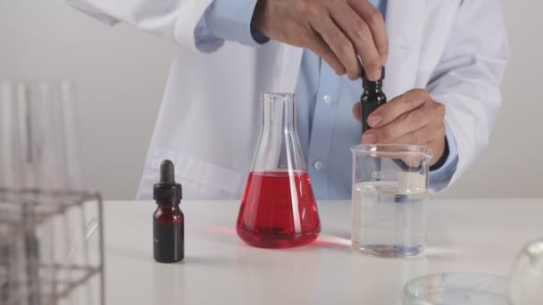 Young Scientist Man Lab Coat Drop Blue Solution Beaker Aan — Stockvideo