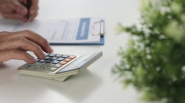 İş adamının eli, hesap makinesini kamyona yükle ve rapor yaz. Beyaz Masa Ofisinde Çalışan İşadamı