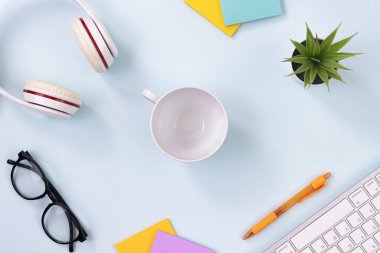 Center Coffee Cup ve Ofis Malzemeleri Klavye, Kulaklık, Kalem, Yapışkan Not, Ofis Bitkileri, Modern Temiz Kreatif Ofis Masasındaki Gözlükler veya Üst Görünüşte Masa