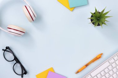 Modern Temiz Yaratıcı Ofis Masası veya Masa Üst Görünüm Masası veya Düz Yat ve Kırtasiye Klavye, Kulaklık, Kalem, Yapışkan Not, Ofis Bitkileri, Gözlükler. Çalışma Alanı Minimalist Arkaplan ve Ofis Malzemeleri