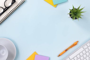 Modern Temiz Yaratıcı Ofis Masası veya Masa Üst Görünüm Masası veya Düz Yat ve Kırtasiye Klavye, Spiral Not Defteri, Kalem, Yapışkan Not, Ofis Bitkileri, Gözlükler, Kahve Kupası. Mavi Pastel Minimalist Arkaplan