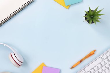 Modern Temiz Yaratıcı Ofis Masası ya da Masa Üst Görünüm Masası ya da Düz Yat ve Kırtasiye Klavye, Kulaklık, Kalem, Yapışkan Not Defter, Spiral Not Defteri, Ofis Bitkileri. Minimalist Özgeçmiş ve Ofis Malzemeleri