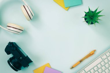 Modern Temiz Yaratıcı Ofis Masası veya Masası Üst Görünümde veya Düz Yatakta ve Kırtasiye Klavye, Kulaklık, Kalem, Yapışkan Not, Ofis Bitkileri, Aynasız Dijital Kamera olarak. Vintage Tonda Minimalist Arkaplan