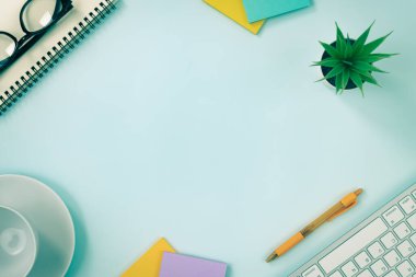 Modern Temiz Yaratıcı Ofis Masası veya Masa Üst Görünüm Masası veya Düz Yat ve Kırtasiye Klavye, Spiral Not Defteri, Kalem, Yapışkan Not, Ofis Bitkileri, Gözlükler, Kahve Kupası. Vintage Tonda Pastel Arkaplanı