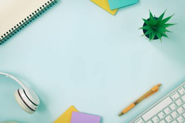 Modern Temiz Yaratıcı Ofis Masası ya da Masa Üst Görünüm Masası ya da Düz Yat ve Kırtasiye Klavye, Kulaklık, Kalem, Yapışkan Not Defter, Spiral Not Defteri, Ofis Bitkileri. Vintage Tonda Minimalist Arkaplan