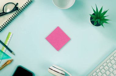 Pembe Not Defteri veya Not Defteri ve Ofis Malzemeleri Klavye, Kalem, Ofis Bitkileri, Not Defteri, Gözlükler, Akıllı Telefon, Kulaklık, Modern Temiz Ofis Masasında Kahve Kupası veya Vintage Ton Top View 'da Masa