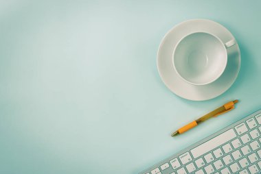 Modern Clean Creative Office Desk veya Office Table on Top View veya Flat Lay üzerine kahve kupası ve kalem ve bilgisayar klavyesi. Mavi Çalışma Alanı Minimalist Arkaplan ve Klasik Ton Ofis Malzemeleri