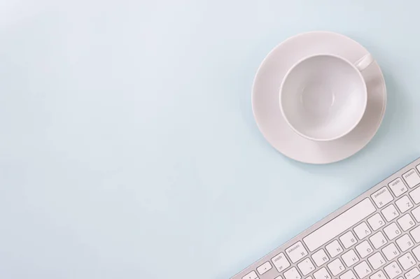 Coffee Cup and Pen and Computer Keyboard on Modern Clean Creative Office Desk or Office Table on Top View or Flat Lay. Blue Workspace Minimalist Background and Office Supplies