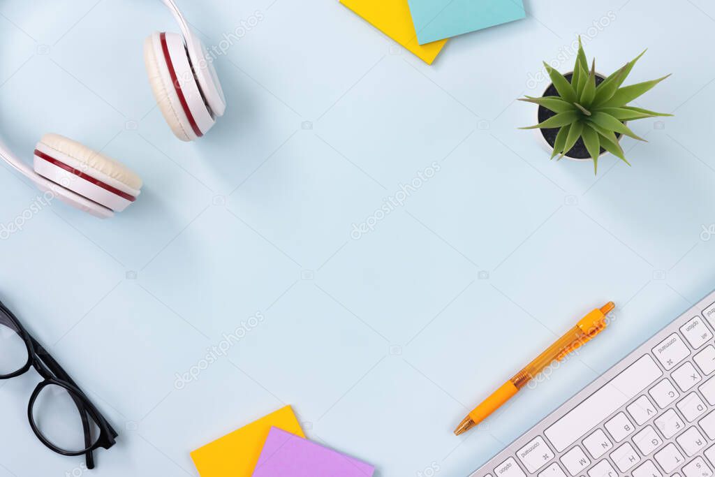 Modern Clean Creative Office Desk or Table on Top View or Flat Lay and Stationery Such as Keyboard,Headphone,Pen,Sticky Note,Office Plants,Glasses. Minimalist Background and Office Supplies