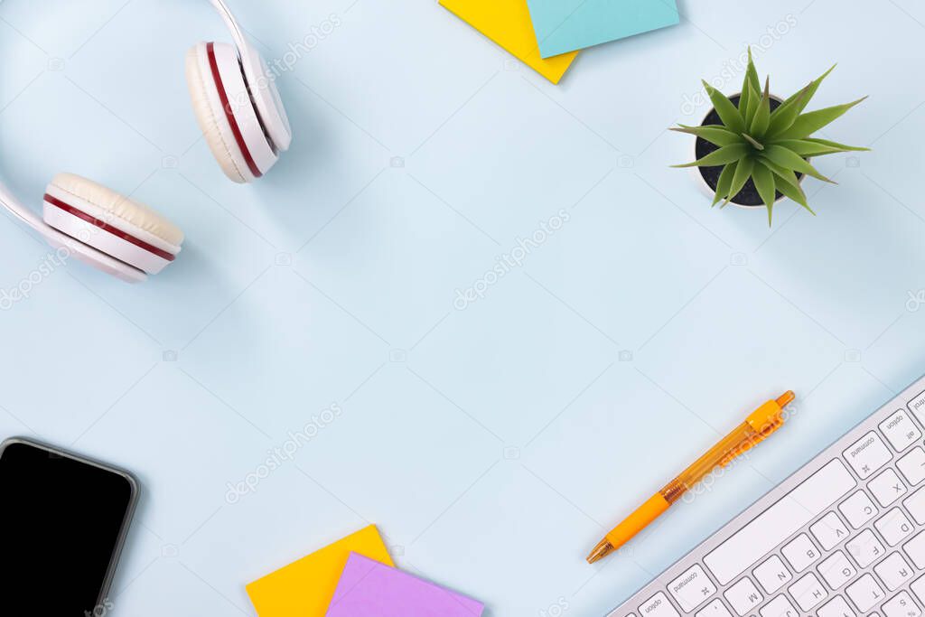 Modern Clean Creative Office Desk or Table on Top View or Flat Lay and Stationery as Keyboard,Headphone,Pen,Sticky Note,Office Plants,Mobile Phone. Minimalist Background and Office Supplies