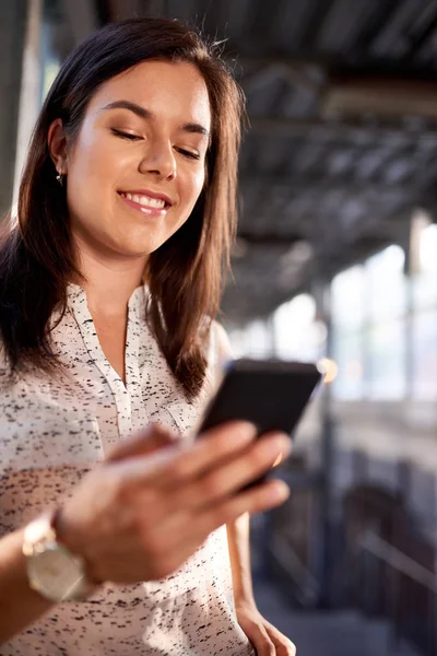 Estudante millennial confiante em movimento verificando seu telefone inteligente em uma plataforma de trem — Fotografia de Stock