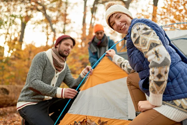 Grupo de excursionistas canadienses instalando una tienda de campaña en un bosque de otoño — Foto de Stock