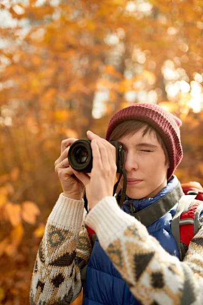 Atractiva chica caucásica tomando fotos con una cámara sin espejo a través del bosque en el otoño en Canadá — Foto de Stock