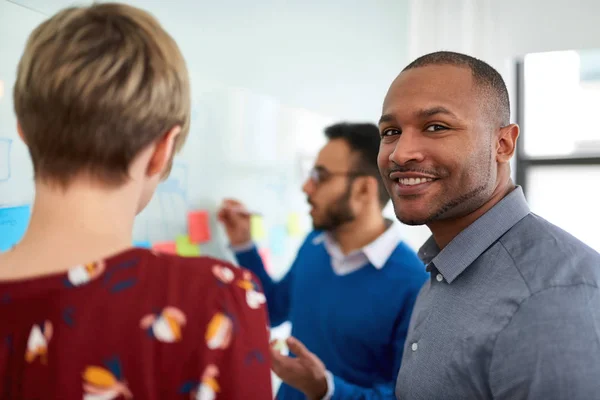 Diverse team of creative millennial coworkers in a startup brainstorming strategies in a positive environment — Stock Photo, Image