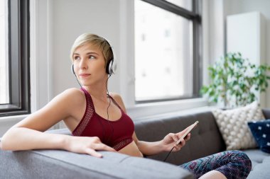 Trendy kadın onu mindfulness sabah rutin bir parçası olarak bir meditasyona app için dinleme