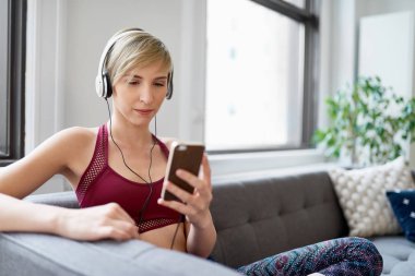 Trendy kadın onu mindfulness sabah rutin bir parçası olarak bir meditasyona app için dinleme