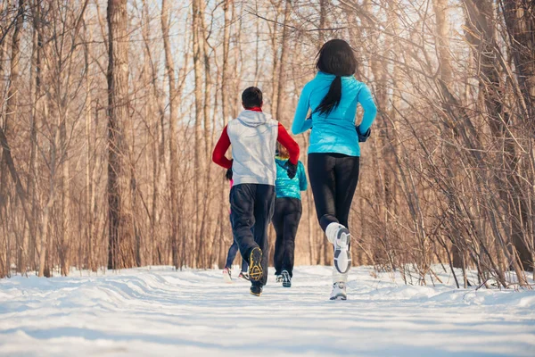 Group of friends enjoying jogging in the snow in winter — Stock Photo, Image