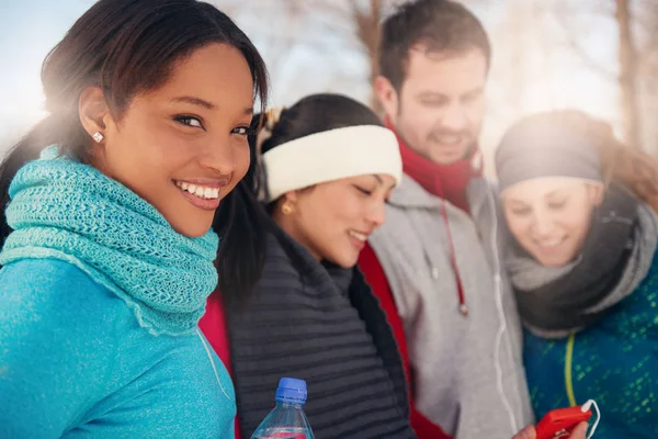 Group of friends listening to music in the snow in winter — Stock Photo, Image