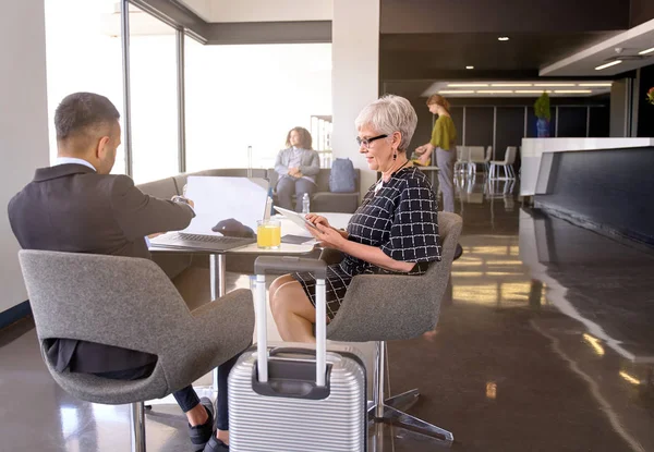 Mosolygó, változatos kollégák ül a modern repülőtér társalgóban a poggyász fejlesztése üzleti ötletek együtt — Stock Fotó