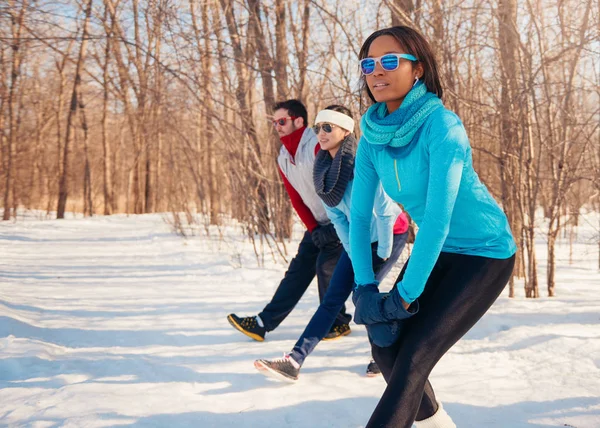 Group of friends stretching in the snow in winter — Stock Photo, Image