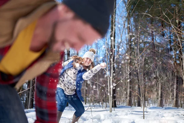 Familia feliz con hijo disfrutando jugando en nieve fresca durante el invierno y teniendo una pelea de bolas de nieve — Foto de Stock