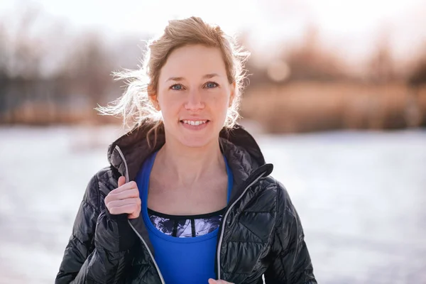 Sporty caucasian woman keeping fit in the winter and going outside in a snow filled city — Stock Photo, Image