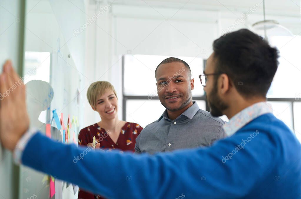Diverse team of creative millennial coworkers in a startup brainstorming strategies