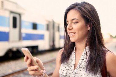 Bin yıllık kendinden emin öğrenci akıllı telefonunu kontrol ediyor.