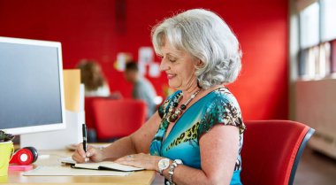 Kırmızı kreatif masasında çalışan kendine güvenen bayan tasarımcı