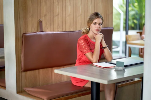 Nahaufnahme Lifestyleporträt einer jungen nachdenklichen blonden kaukasischen Millennial-Geschäftsfrau, die in einem hellen modernen Restaurant Notizen macht und helle Kleidung trägt — Stockfoto