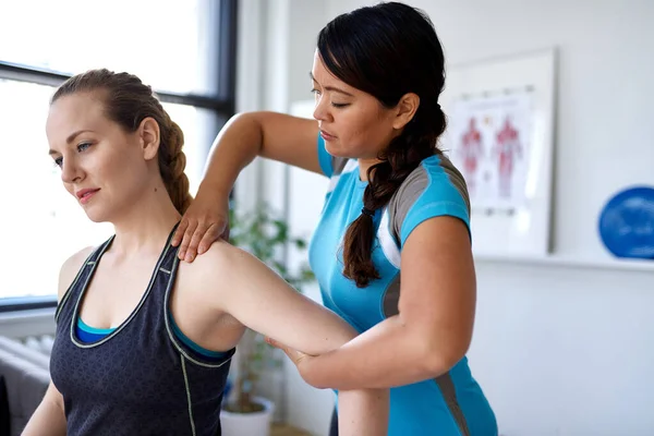 Donna cinese fisioterapia professionale dando un trattamento a un — Foto Stock