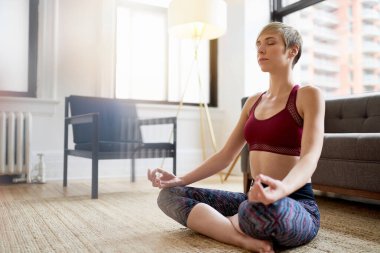 Trendy kadın onu farkındalık sabah rutin bir parçası olarak yoga yapıyor