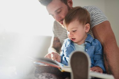Sevimli, genç bir bayan çocuk. Elle kitap okumayı öğreniyor.