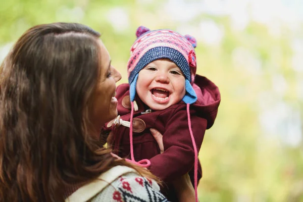 Lycklig familj med mor och dotter med varm hatt i parken — Stockfoto