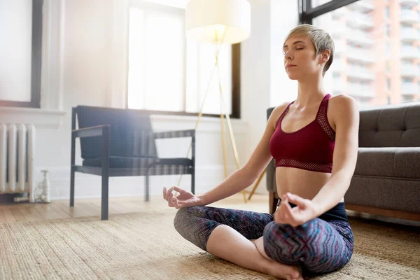 Donna alla moda che fa yoga come parte della sua routine mattutina di consapevolezza — Foto Stock